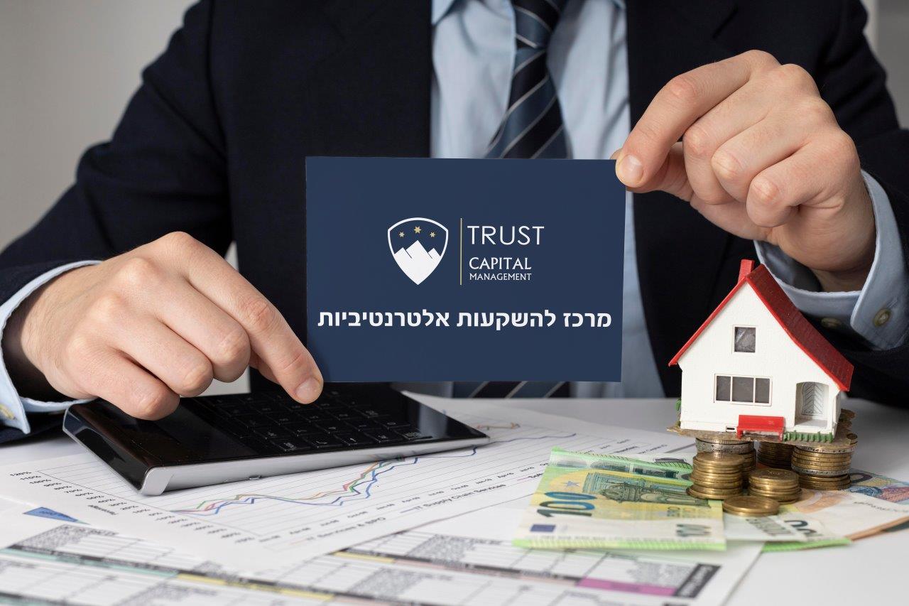 איש מחזיק כרטיס ביקור שכתוב עליו מרכז להשקעות אלטרנטיביות עם הלוגו וכסף על השולחן עם מחשבון