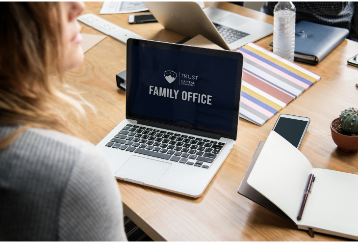 אישה מסתכלת על מחשב שכתוב family office טראסט קפיטל